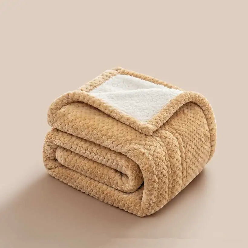Folded beige blanket with white fleece lining on a beige background
