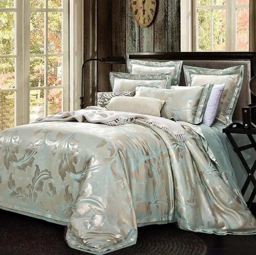 Decorative bedspread with floral patterns on a bed in a room with large windows.