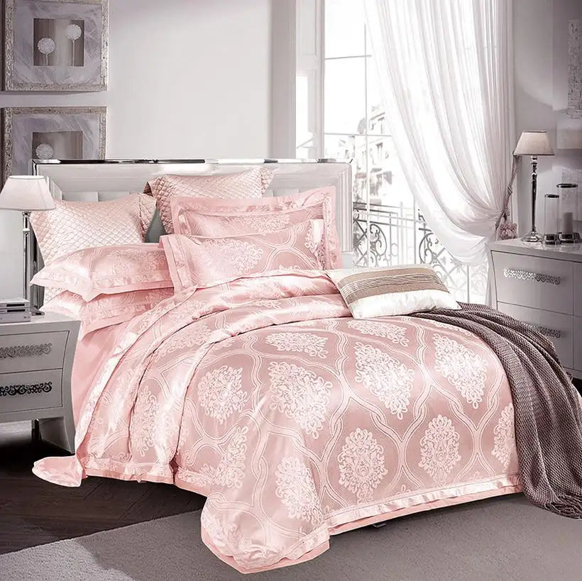 Pink floral patterned comforter set on a bed in a bedroom with white curtains and decor.