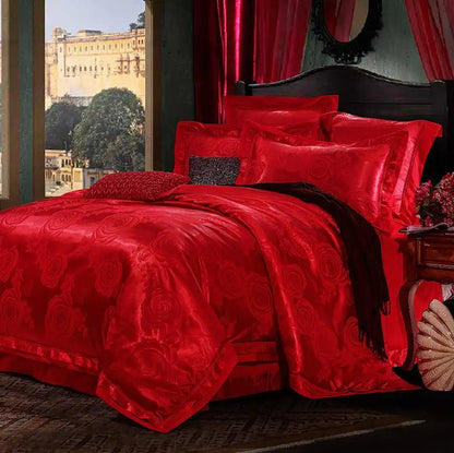 Red bedspread with intricate patterns on a bed in a room with large windows.