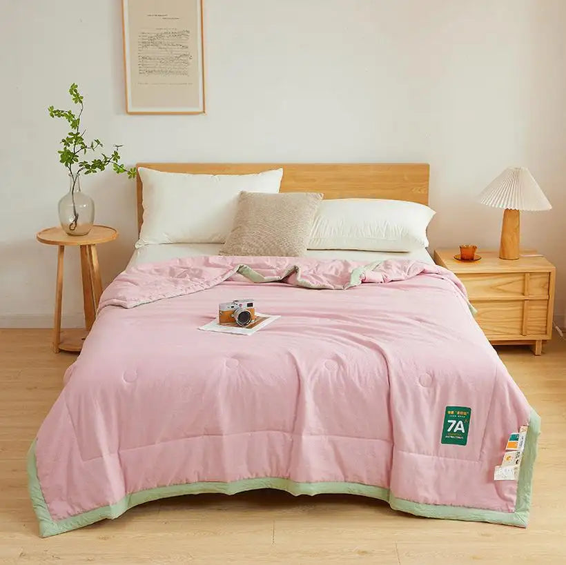 Bedroom with pink comforter, wooden headboard, and side tables.