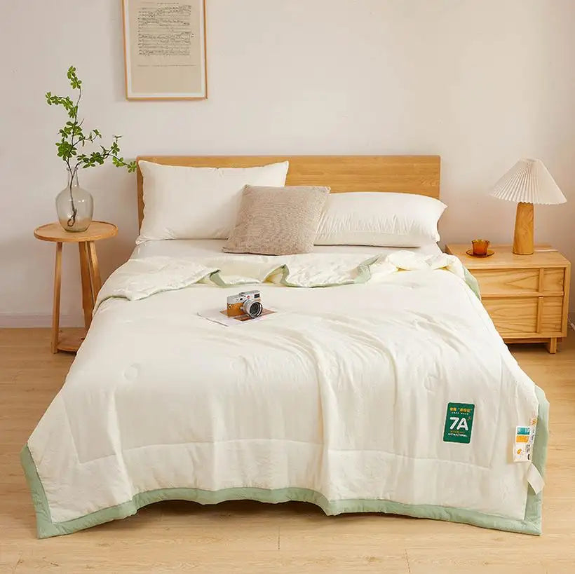 Bed with white bedding and green trim in a bedroom setting