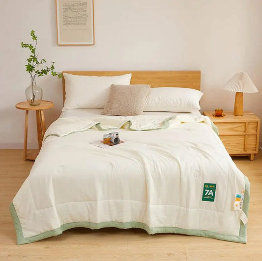 Bed with white bedding and green trim in a bedroom setting