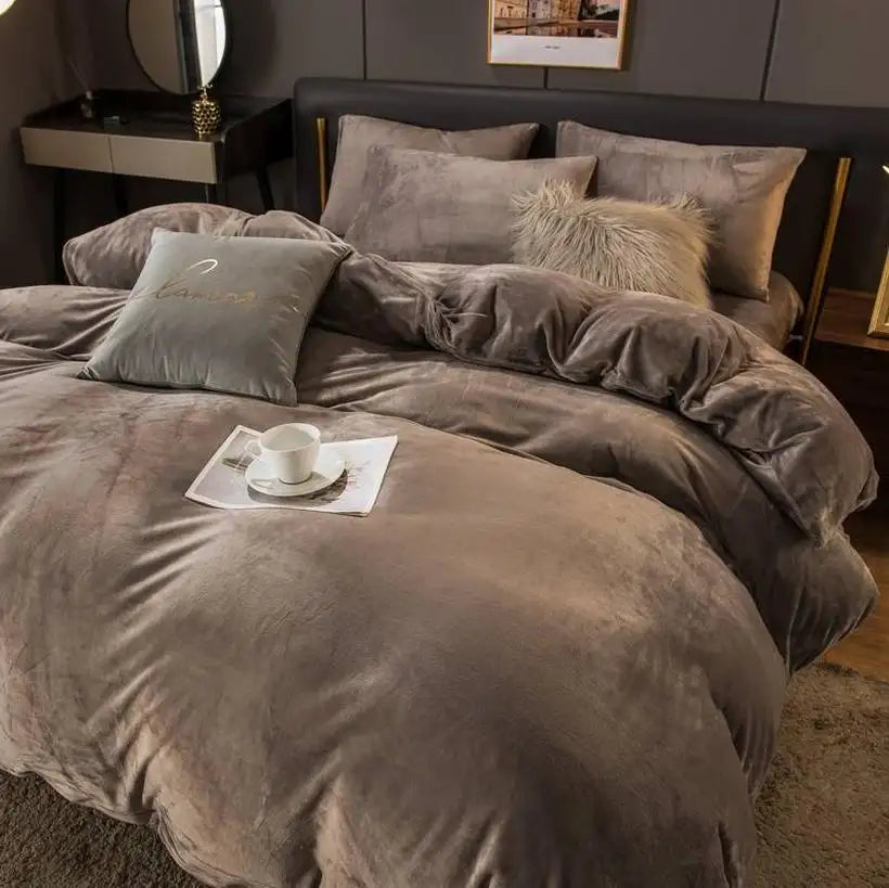Gray textured bedding set on a bed with a cup and saucer on a tray.