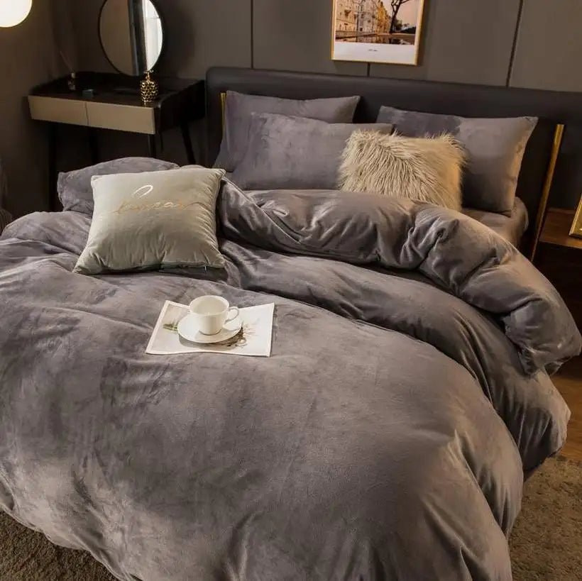 Gray textured bedding set on a bed with a cup and saucer on a tray.
