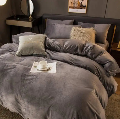 Gray textured bedding set on a bed with a cup and saucer on a tray.
