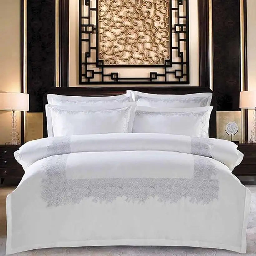 White bedding set with decorative patterns on a bed in a stylish bedroom.