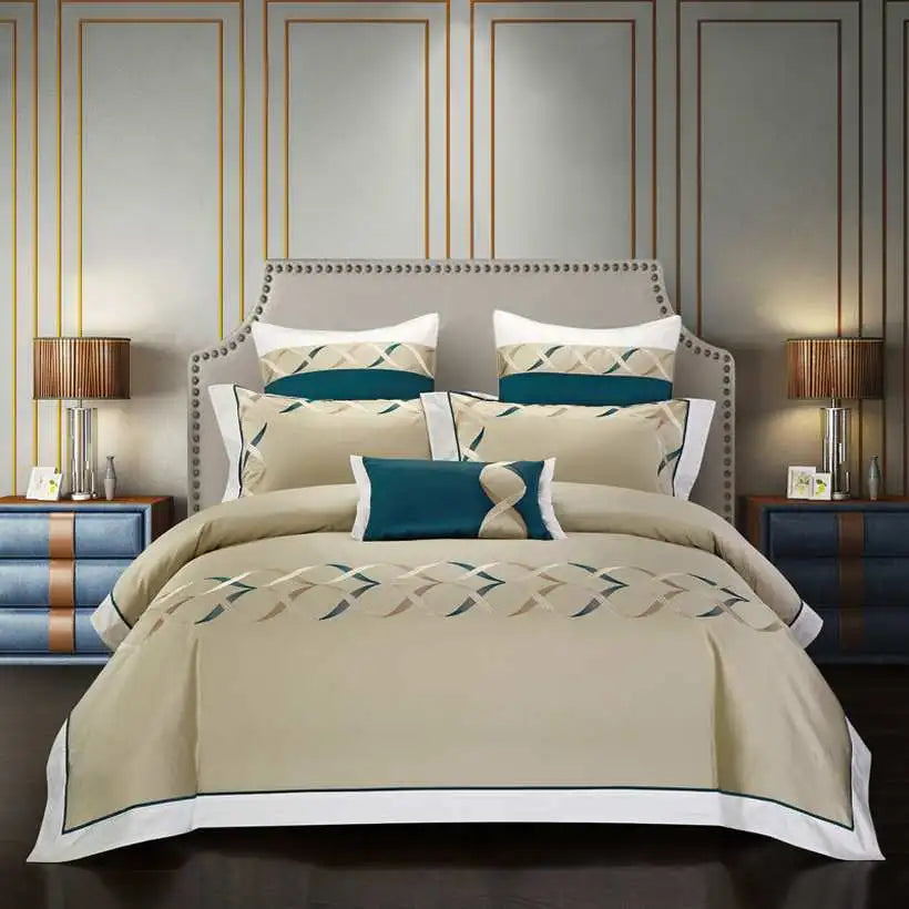 Neatly made bed with beige and blue bedding in a bedroom setting.