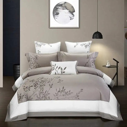 Bedroom with gray floral bedding set on a bed, wall art, and side table.