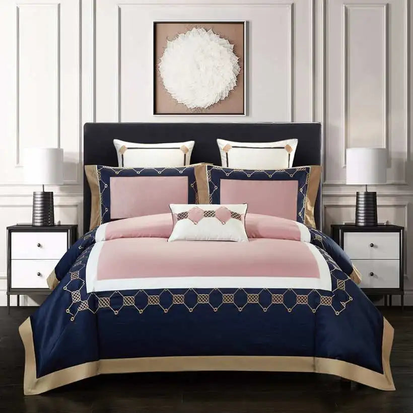 Navy and pink bedspread set on a bed with matching pillows in a bedroom setting.