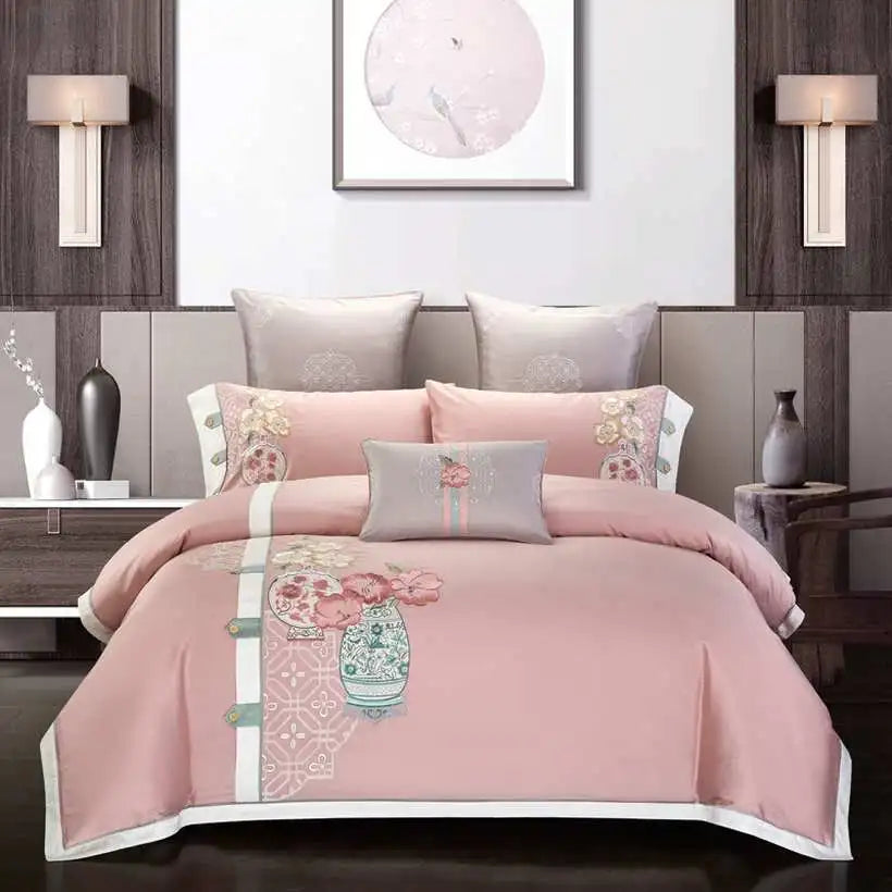 Pink floral bedding set on a bed in a bedroom setting with wall art and lamps.