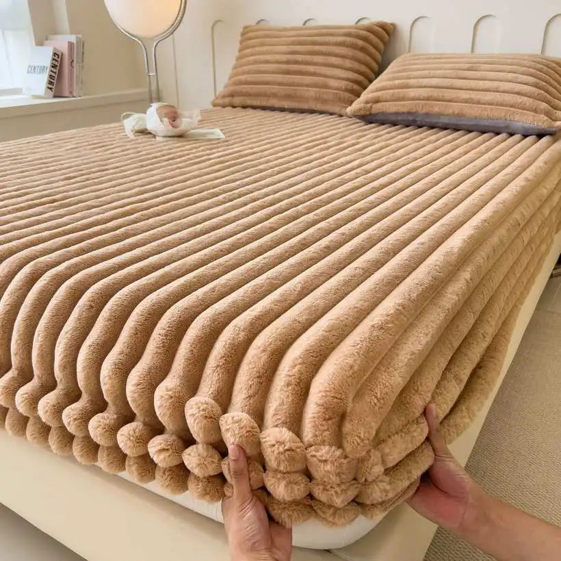 Folded beige flannel blanket on a bed with pillows