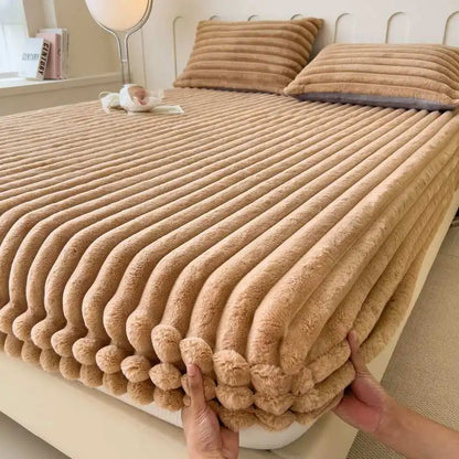 Folded beige flannel blanket on a bed with pillows