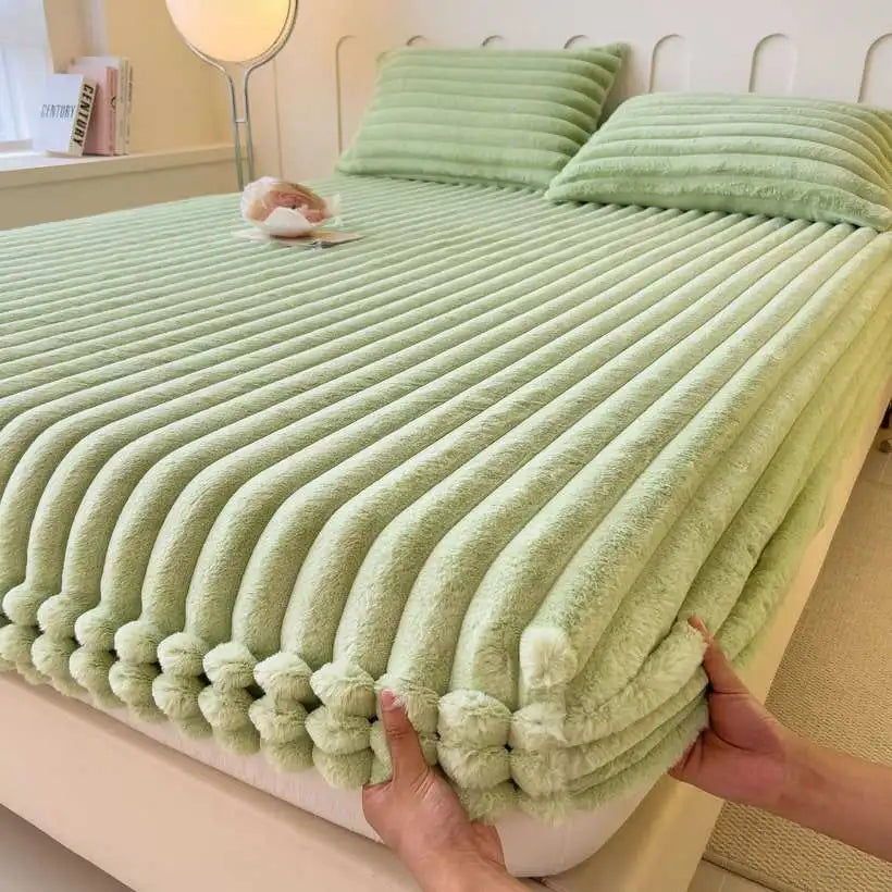 Green textured blanket being held over a bed in a bedroom setting