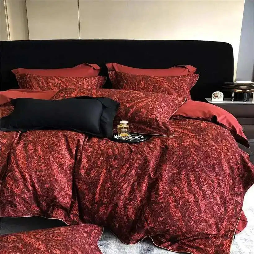 Red patterned bedding set on a bed with black pillows.