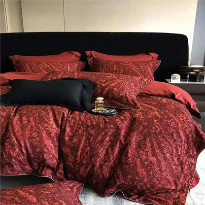 Red patterned bedding set on a bed with black pillows.