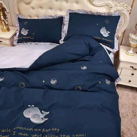 Navy blue bedding set with whale designs on a bed in a bedroom.