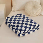Blue and white checkered blanket on a bed with pillows