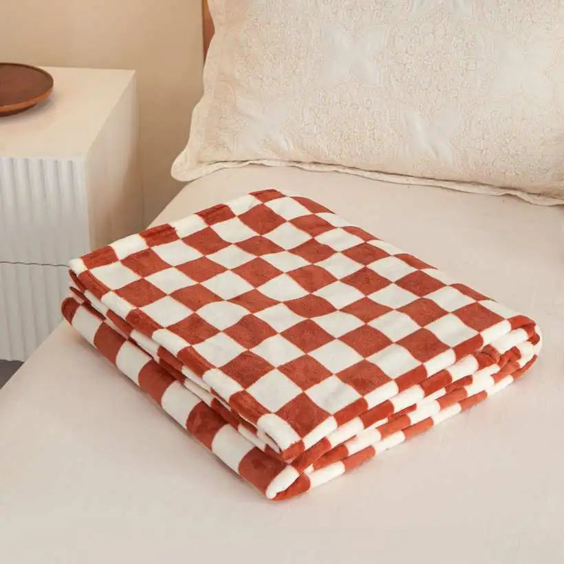 Folded red and white checkered blanket on a bed
