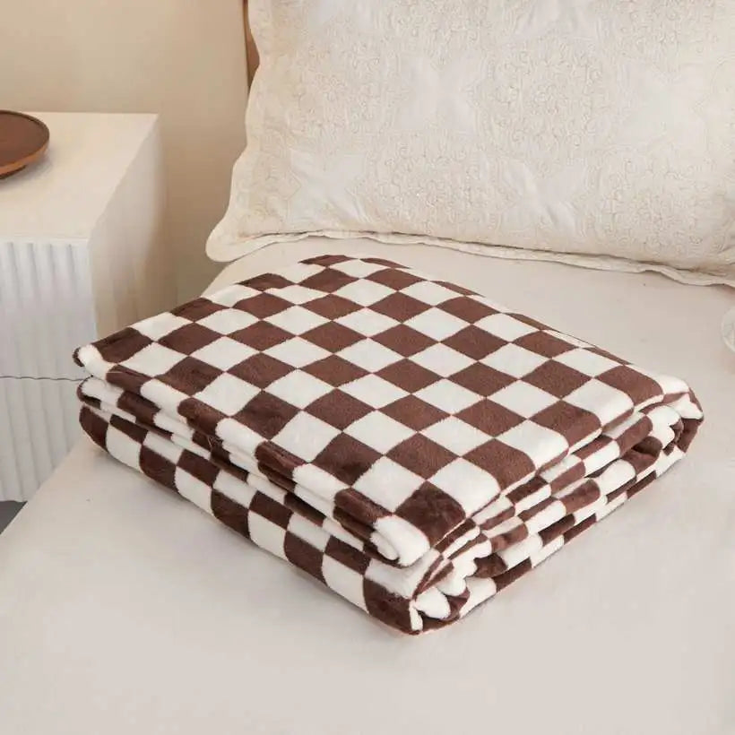 Folded brown and white checkered blanket on a bed