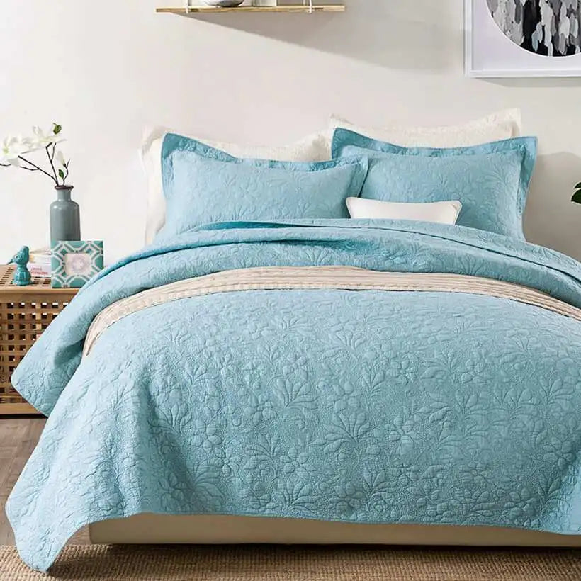 Blue quilt set on a bed in a bedroom setting