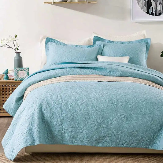 Blue quilt set on a bed in a bedroom setting