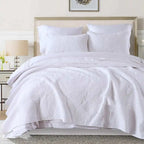 White textured comforter set on a bed in a bedroom setting