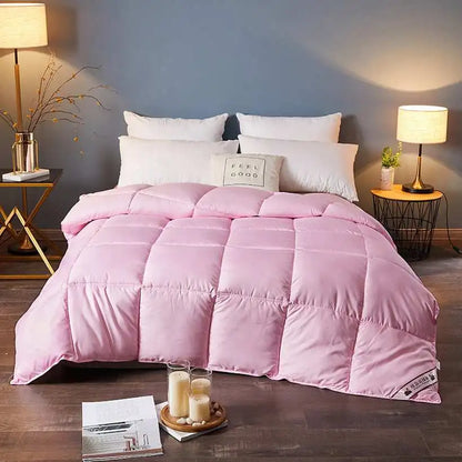 Pink comforter on a bed in a bedroom setting with lamps and decor.