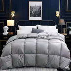 Gray quilted comforter on a bed in a stylish bedroom with dark walls and decorative elements.