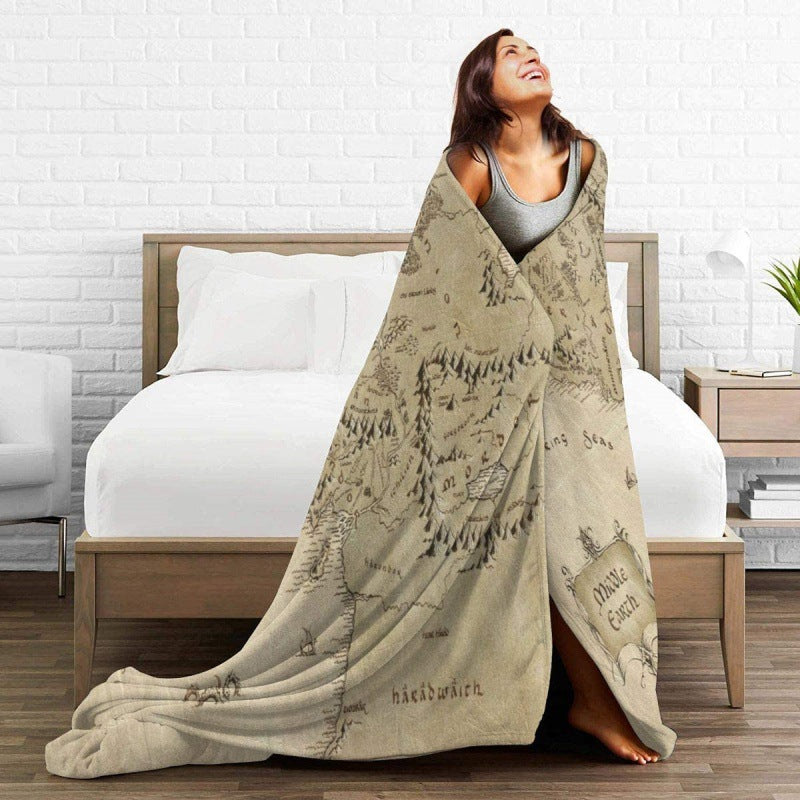 Woman wrapped in a map-themed blanket on a bed @chichicmart